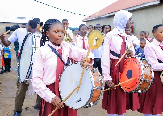 Aheebwa Lilian playing a drum with the Asaba Memorial High School brass band