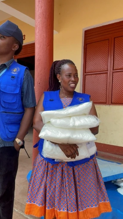 Headteacher Christine holding donated mosquito nets